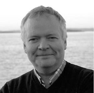 Svartvit porträttbild av en man mot bakgrund av vatten.