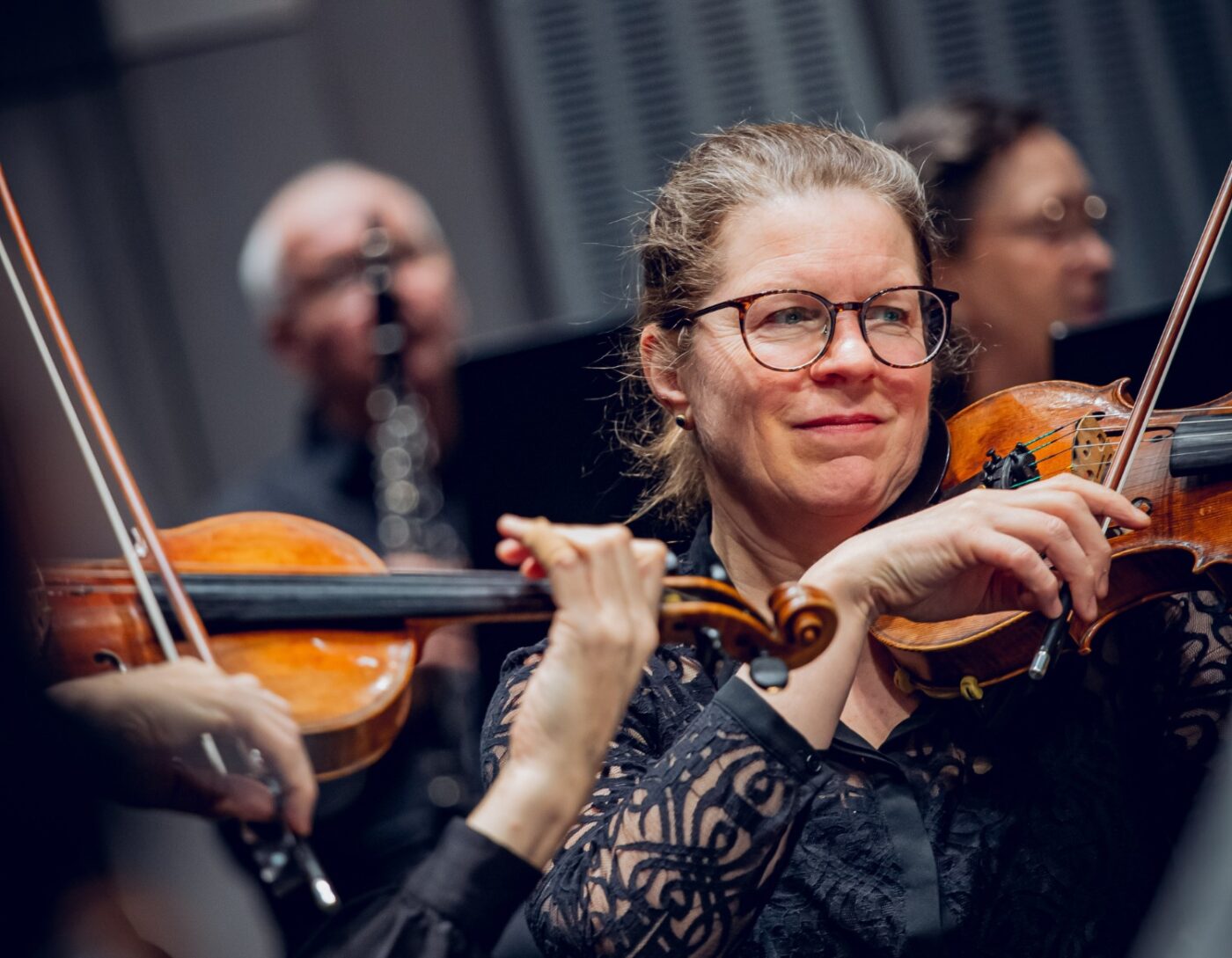 Musiker med en kvinnlig violinist i fokus spelar på sina stråkinstrument
